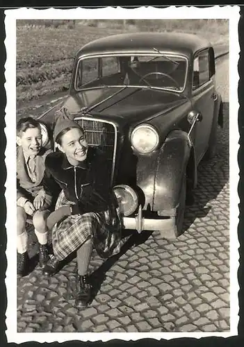 Fotografie Auto Opel, Mädchen & Knabe auf Stossstange sitzend, Einbeck 1951
