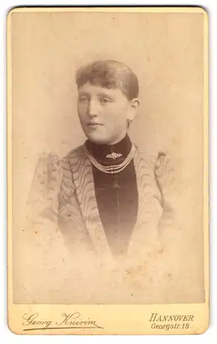 Fotografie Georg Knirim, Hannover, Georgstrasse 18, Portrait junge Dame im Blazer mit Perlenkette und Brosche