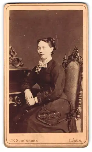 Fotografie C. F. Schönborn, Husum, Schlossstr. 18, Portrait Dame im dunklen Biedermeierkleid mit Hochsteckfrisur