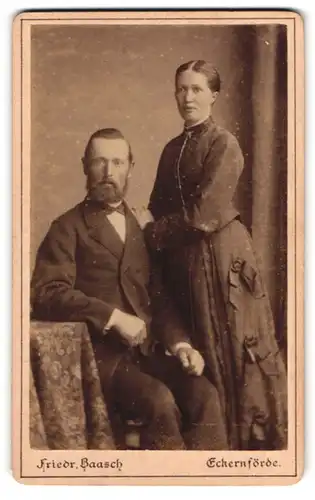 Fotografie Friedr. Baasch, Eckernförde, Nicolaistr. 47, Portrait Paar im Biedermeierkleid mit Schleifen und Anzug