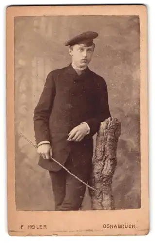 Fotografie F. Heiler, Osnabrück, Grosse Str. 28, Portrait junger Mann im Anzug mit Weidenstock und Hut
