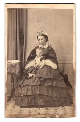 Fotografie unbekannter Fotograf und Ort, Portrait Mutter im reifrock Kleid mit Tochter auf dem Schoss, Mutterglück