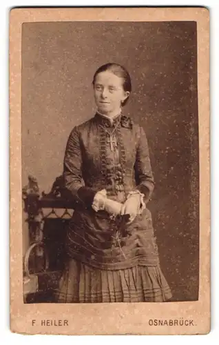 Fotografie F. Heiler, Osnabrück, Grosse Strasse 28, Frau mit Kreuz im taillierten Kleid