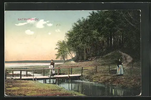 AK Satrupskov, Frauen am Fluss mit kleiner Holzbrücke