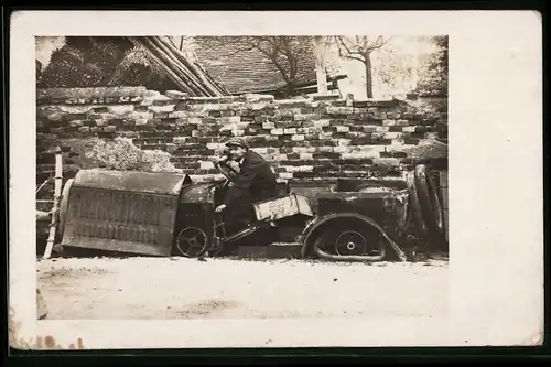 Fotografie Bursche sitzt im Auto-Wrack Ersatzteilspender