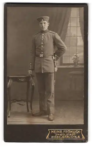 Fotografie Heinr. Fröhlich, Ingolstadt, Ziegelbräustr. 4, Portrait junger Soldat in Feldgrau Uniform mit Bajonett