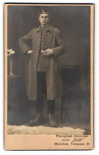 Fotografie Steininger, München, Türkenstr. 31, Portrait junger Soldat in Feldgrau Uniform mit Mantel und Krätzchen