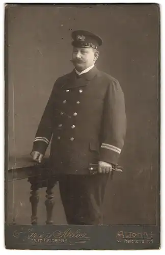 Fotografie Hans Atelier, Altona, Reichenstr. 1, Portrait hamburger Binnenschiffer in Uniform mit Schirmmütze