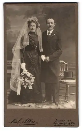 Fotografie Mich. Alber, Augsburg, Jesuitengasse 414, Portrait Brautpaar im schwarzen Kleid mit Schleier und Anzug