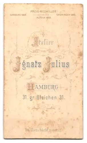 Fotografie J. Julius, Hamburg, Schöne Frau mit geflochtener Hochsteckfrisur und edler Kleidung