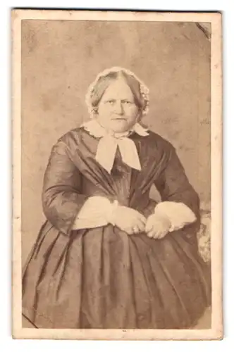 Fotografie unbekannter Fotograf und Ort, Alte Frau in tailliertem Kleid und bösem Blick