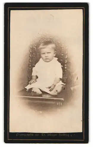 Fotografie Th. Böttger, Freiberg i. S., Schmollendes Kind mit dicken Wangen und nackten Füssen
