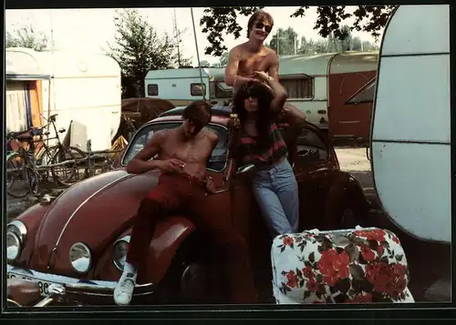 Fotografie Auto VW Käfer, junge Brünette Frau mit Volkswagen & Wohnwagen auf einem Campingplatz 1981