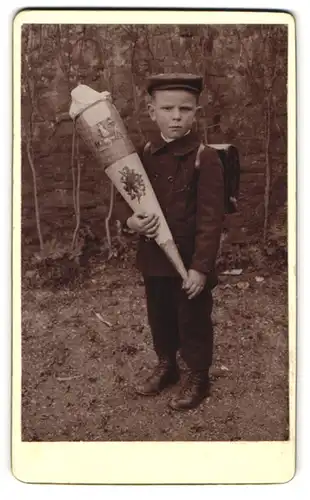 Fotografie unbekannter Fotograf und Ort, Portrait junger Knabe mit Schulranzen und Zuckertüte zur Einschulung