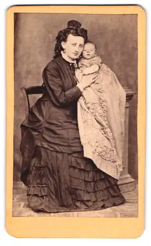 Fotografie V. M. Wagenhäuser, Münnerstadt, Portrait stolze Mutter im Biedermeierkleid mit Baby im Arm, Mutterglück