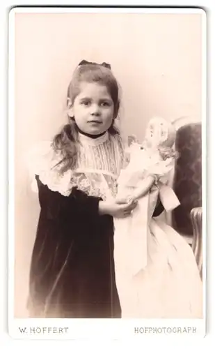 Fotografie W. Höffert, Hamburg, Esplanade 47, Portrait niedliches Mädchen im Samtkleid mit Puppe im Arm