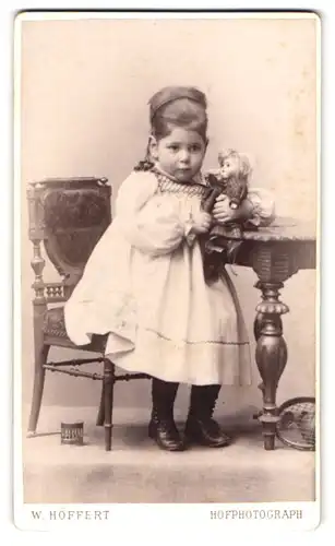 Fotografie W. Höffert, Hamburg, Jungfernstieg 12, Portrait niedliches Mädchen im weissen Kleid mit Puppe im Arm