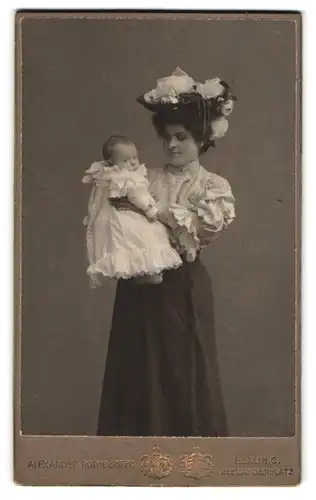 Fotografie Alexander Rothberger, Berlin, Alexanderplatz, Portrait Mutter im Kleid mit Hut zeigt Ihr Kind, Mutterglück