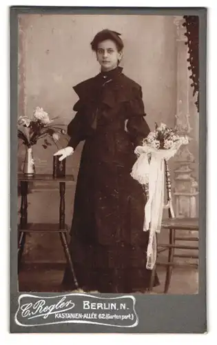 Fotografie C. Regler, Berlin, Kastanien-Allee 62, Portrait junge Frau im schwarzen Kleid mit Kommunionsstrauss