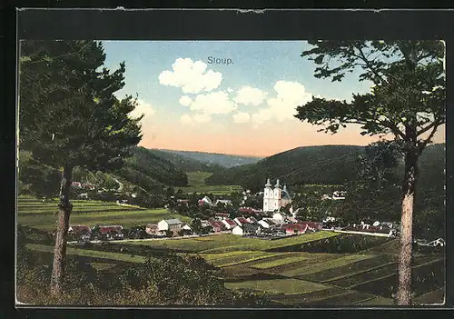 AK Sloup, Ortsansicht mit der Kirche vom Wald aus gesehen