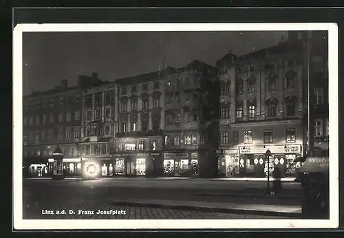 AK Linz, Franz Josef Platz romantisch beleuchtet bei Nacht
