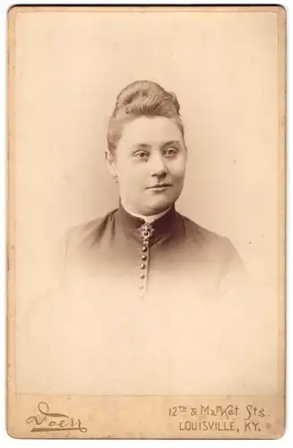 Fotografie Doerr, Louisville / KY, 12th Market St., Portrait junge Frau im Kleid mit Brosche und Dutt