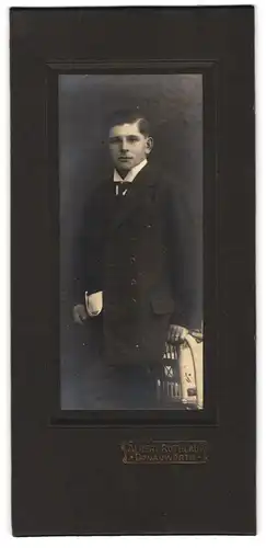 Fotografie Albert Rothlauf, Donauwörth, Portrait junger Mann im dunklen Anzug mit Zeitung in der Hand