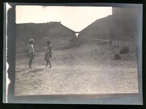 Fotografie unbekannter Fotograf, Ansicht Aden, Einheimische am Stadtrand, Brückentor im Hintergrund
