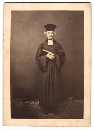 Fotografie Bibliothek Archiv Novotny, Ort unbekannt, Portrait älterer Pfarrer im Talar mit Collar, frühe Fotografie