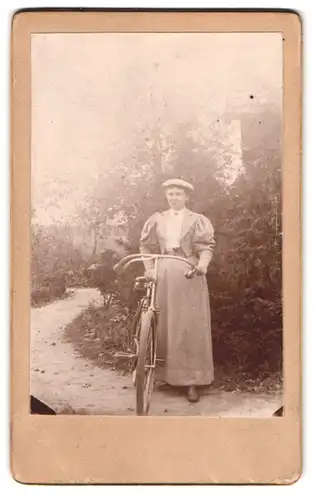 Fotografie unbekannter Fotograf und Ort, junge Frau im Kleid mit ihrem Fahrrad im Garten
