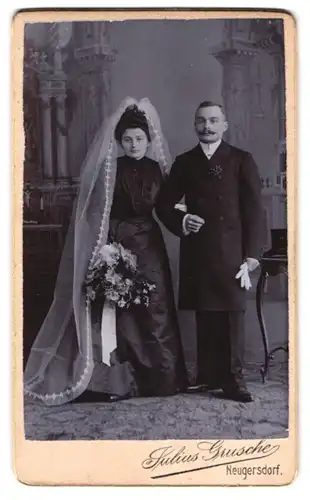 Fotografie Julius Grusche, Neugersdorf i. S., Portrait Brautpaar im schwarzen Kleid mit Schleier und Anzug mit Zylinder