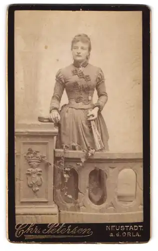 Fotografie Chr. Petersen, Neustadt / Orla, hübsche Dame steht im eleganten Kleid an einem Geländer