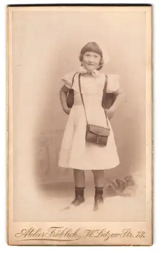 Fotografie Atelier Fröhlich, Berlin, Lützow-Str. 73, Portrait lächelndes Mädchen mit Schulranzen und Umhängetasche