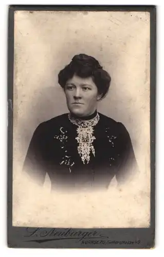 Fotografie L. Neuburger, Nürnberg, Fürtherstr. 49, Portrait dunkelhaarige Dame mit Dutt und Stickerei am Blusenkragen