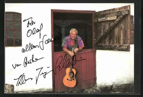 AK Musiker Klaus-Jürgen Schlettwein lehnt mit seiner Gitarre an einer Stalltür