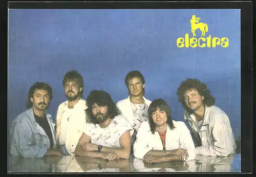 AK Musikgruppe Electra steht zusammen an einem Tisch
