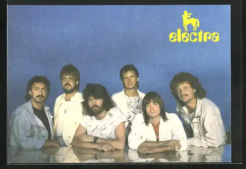 AK Musikgruppe Electra steht zusammen an einem Tisch