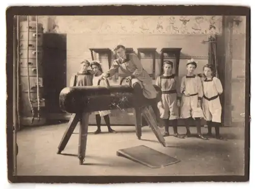 Fotografie Mädchen beim Sport in einer Turnhalle, Turnübung auf dem Pauschenpferd