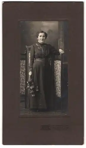 Fotografie R. Märklin, Freiburg i. Br., Kaiserstr. 10, betagte Dame mit Blumenstrauss trägt schwarzes Kleid
