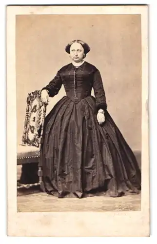Fotografie unbekannter Fotograf und Ort, Portrait Dame im Biedermeierkleid mit Halskette lehnt an einem Stuhl