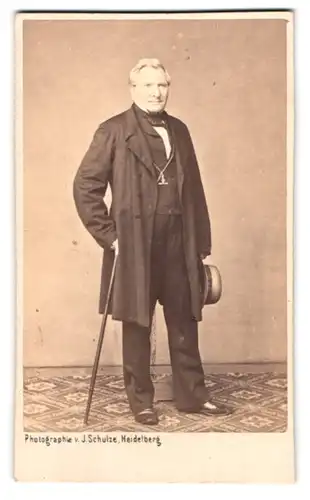 Fotografie J. Schulze, Heidelberg, Portrait Herr im Anzug mit Spazierstock und Hut in der Hand
