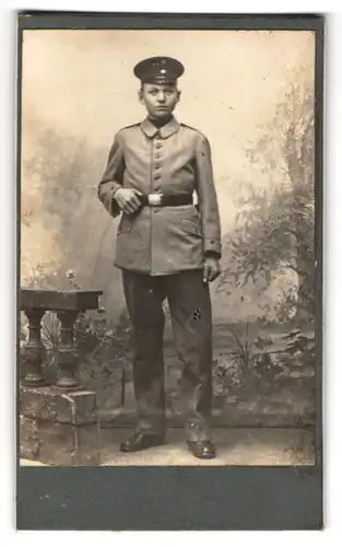 Fotografie unbekannter Fotograf und Ort, Portrait junger Soldat in Uniform posiert im Atelier