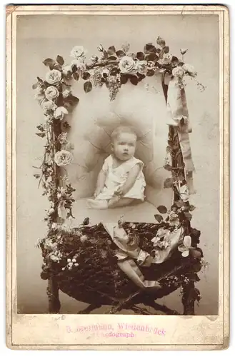 Fotografie Bernhard Breimann, Wiedenbrück i. W., Fotomontage Baby sitzt im mit Blumenn geschmückten Sessel