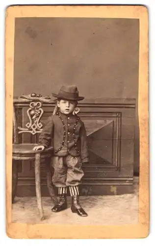 Fotografie M. Wild, Burghausen, Portrait Knabe mit Hut in übergrossen Schuhen & gestreiften Strümpfen
