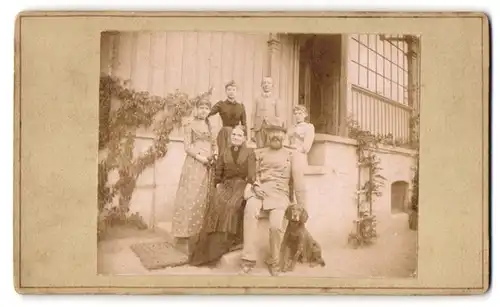 Fotografie Jäger mit Jagdhund von Familie umgeben