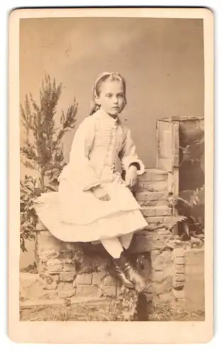 Fotografie Fr. Kahlmeyer, Osnabrück, Bahnhofsplatz 1, blondes Mädchen im weissen Kleid auf Kulisse sitzend