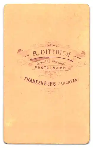 Fotografie R. Dittrich, Frankenberg / Sachsen, Bursche im Anzug mit Zwicker an Tisch lehnend