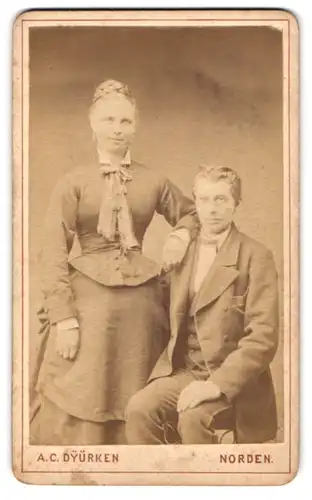 Fotografie A. C. Dyürken, Norden, Neuweg 105, hüsbche Dame mit geflochtenem Haar nebst Gatte im Anzug