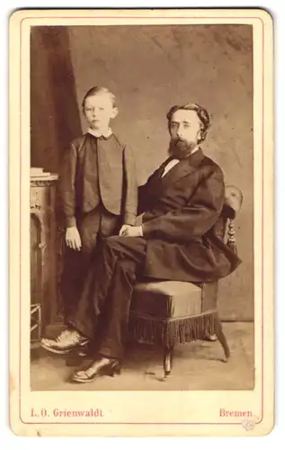 Fotografie L. O. Grienwald, Bremen, Wall 86, Portrait Vater mit seinem Sohn im Anzug posiert im Atelier