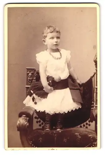 Fotografie Katharina Culié, Frankfurt a. M., Hochstrasse 32, Portrait kleines Mädchen im Kleid mit Puppe